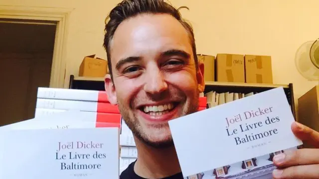 Joël Dicker con dos ejemplares de la edición francesa de 'El libro de los Baltimore'.