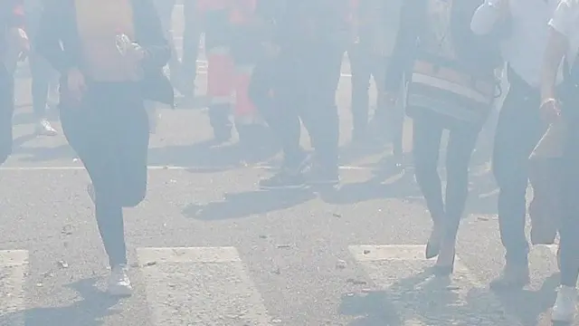 Una aglomeración humana atraviesa la humareda tras el disparo de la última Mascletá oficial de las Fallas en Valencia.