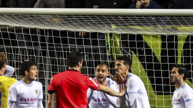 Los jugadores del Real Zaragoza protestan a Díaz de Mera, árbitro del partido del pasado lunes en Cádiz, la decisión del penalti que supuso el 3-3 final ya con el tiempo concluido.