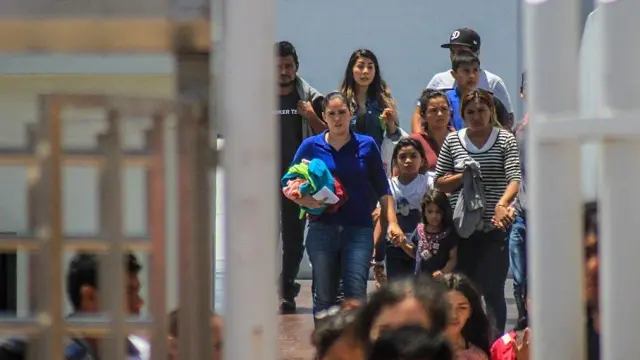 Decenas de inmigrantes retornan este martes a México por la garita del chaparral, en la ciudad de Tijuana.