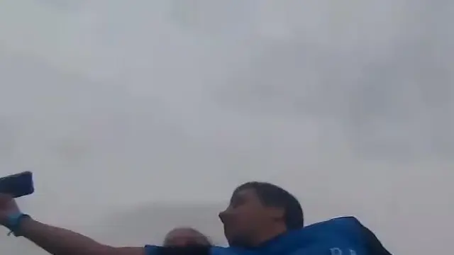 Momento en el que un joven atrapa un móvil al vuelo desde una montaña rusa de PortAventura.