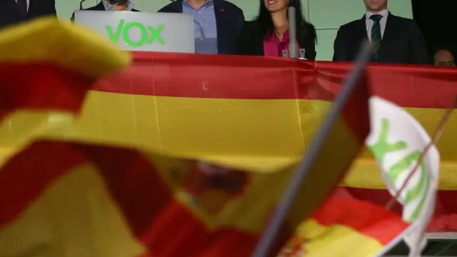 El equipo de Vox saluda a sus simpatizantes en el exterior de la sede de Madrid durante el seguimiento de la noche electoral.