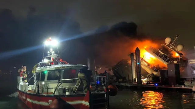 Fotografía cedida por el Departamento de Bomberos de Miami donde se observa a uno de sus barcos mientras se extingue el fuego en el yate 'Andiamo'.