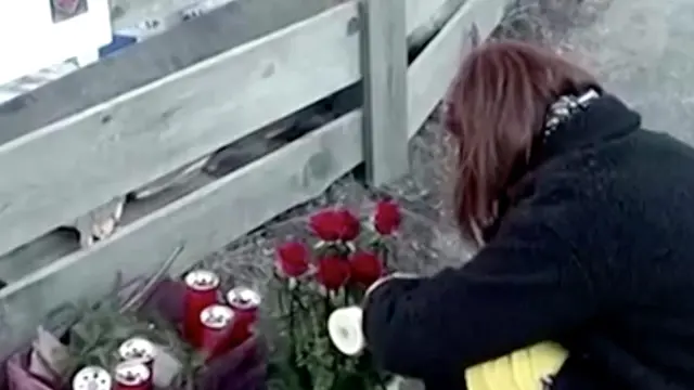 Una mujer enciende una vela en el lugar donde fueron atropellados los jóvenes.