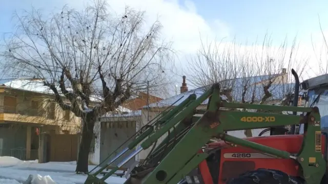 El alcalde de la localidad, Fernando Sánchez, despejando de nieve las carreteras del pueblo con su tractor.