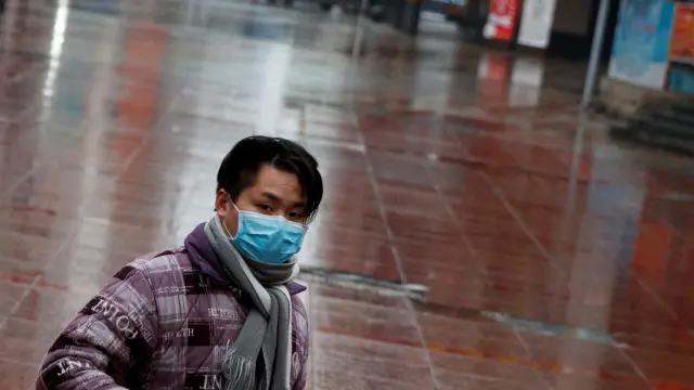 Un hombre con una máscara en un centro comercial de Jiujiang.