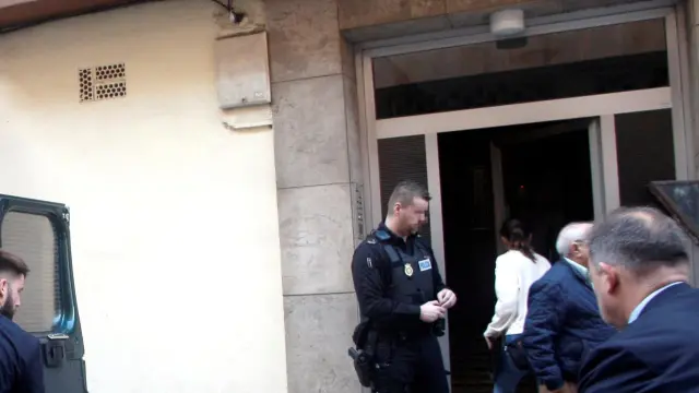 Dos personas trasladan el cadáver de una mujer de 41 años, hallado este lunes por la Policía Local de Gijón con evidentes signos de violencia en su domicilio