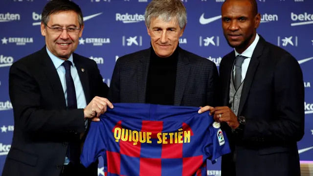 El presidente del FC Barcelona, Josep María Bartomeu (i), y el director deportivo, Eric Abidal (d), junto al nuevo entrenador del club, Quique Setién (c)