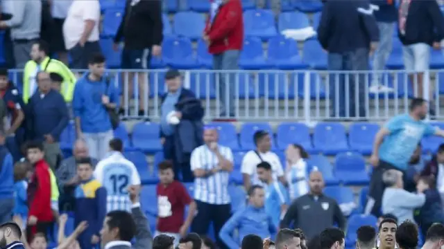 Jugadores, técnicos y auxiliares del Real Zaragoza celebran sobre el césped la victoria en Málaga, saludando a la afición aragonesa que había en las gradas.