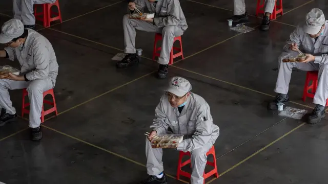 Trabajadores chinos comen en asientos habilitados y colocados para mantener la distancia prudencial recomendada en la fábrica Dongfeng Honda en Wuhan.