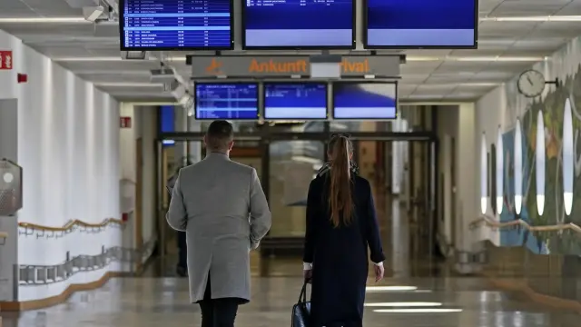 Dos personas caminan por una desierta terminal del aeropuerto de Stuttgart.