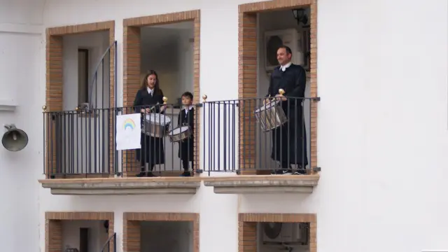 Tocando el tambor y el bombo desde balcones de la plaza del Ayuntamiento de Híjar.