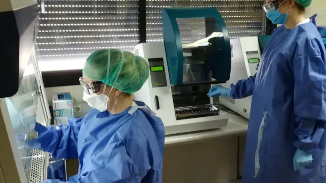 La técnico Marta Navarro manipula una muestra en la campana de seguridad biológica (izquierda), mientras su compañera Cristina Guijarro trabaja con el extractor donado por los empresarios.