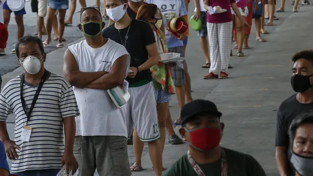 Decenas de filipinos hacen fila en Manila para conseguir alimentos gratis.
