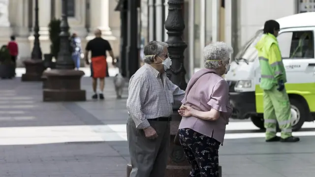 Varias personas guardan la distancia social el domingo en Zaragoza.