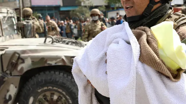 Un soldado evacua a un bebé del hospital atacado en Kabul.