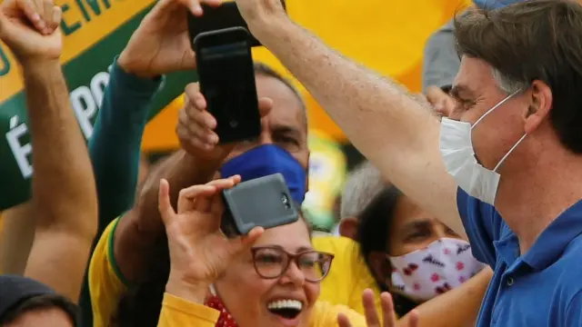 El presidente de Brasil, Jair Bolsonaro, saluda a algunos seguidores, este domingo en Brasilia.