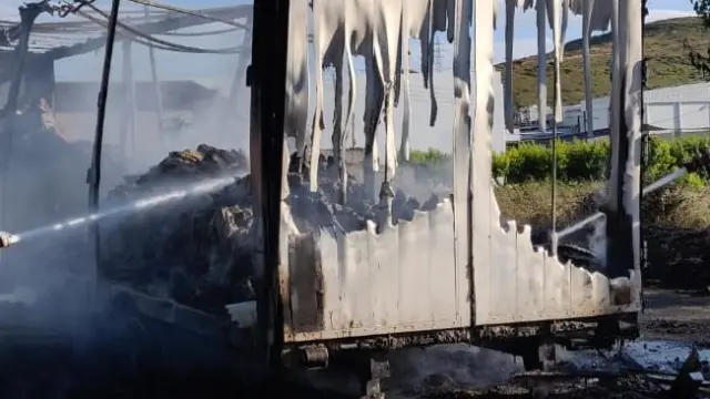 Los bomberos sofocal el incendio en un camión, que ha obligado a desviar el tráfico de la N-211 en Fraga