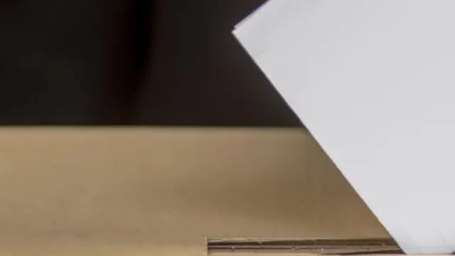 Hand of a person casting a vote into the ballot box during election