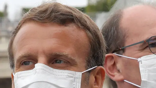 El presidente francés Emmanuel Macron y el primer ministro Jean Castex both wearing, con mascarilla, durante el desfile que conmemora la toma de la Bastilla.