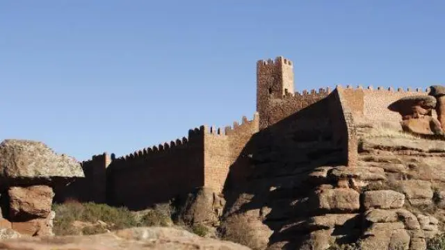Un imponente castillo del siglo XIII de rodeno rojizo se alza en lo alto de la localidad turolense, en las faldas de la Sierra Menera.