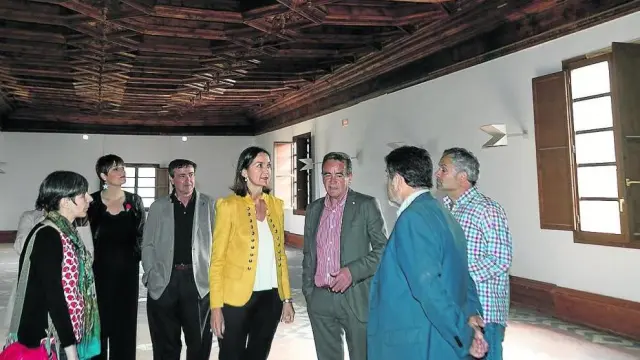 La ministra Reyes Maroto –en el centro–, junto al presidente de la DPZ y representantes políticos, en la biblioteca del siglo XVI durante la visita en mayo de 2019.