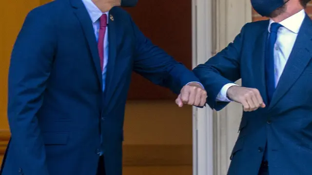 Pedro Sánchez y Pablo Casado se saludan con el codo antes de la reunión de este miércoles.