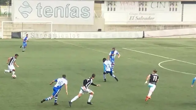 Un jugador del Haro Deportivo avanza con el balón mientras la defensa local trata de frenar su ataque.
