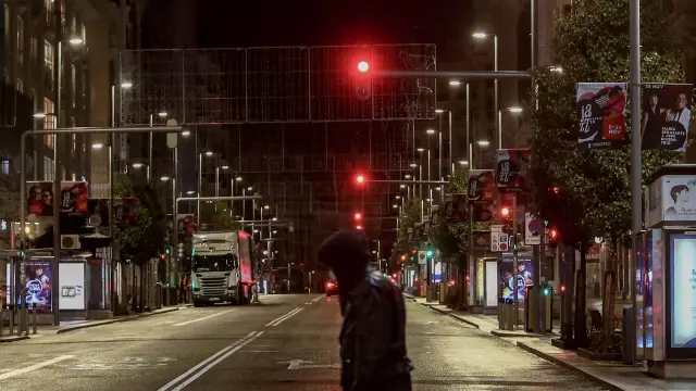 Un joven cruza una calle del centro de Madrid durante la primera noche de toque de queda en la capital.