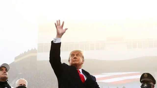 Trump lanza una moneda al aire antes del partido anual de fútbol americano entre la Armada y la Marina, en West Point.