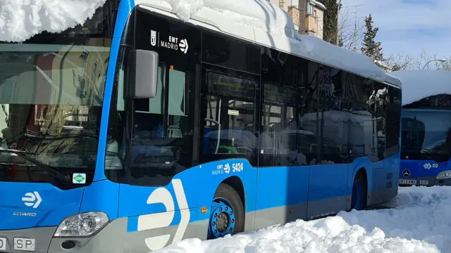 Varios autobuses de la Empresa Municipal de Transportes cubiertos de nieve este domingo en Madrid.