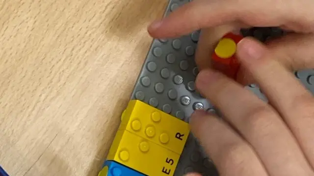 Manos de un niño jugando con piezas Lego
