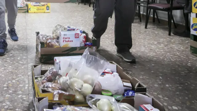 Dos voluntarios mueven un lote de comida para el reparto de la asociación Civitas de Las Fuentes.