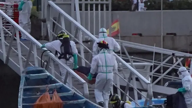 Trabajadores de la Cruz Roja trasladan los cuerpos de inmigrantes fallecidos en un cayuco durante la ruta migratoria hacia Canarias