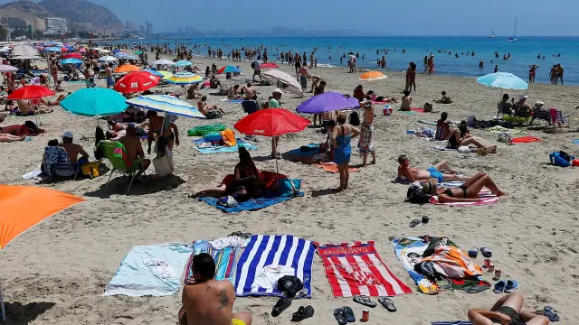 Turistas disfrutan de un soleado día en la playa del Postiguet, este sábado en Alicante.