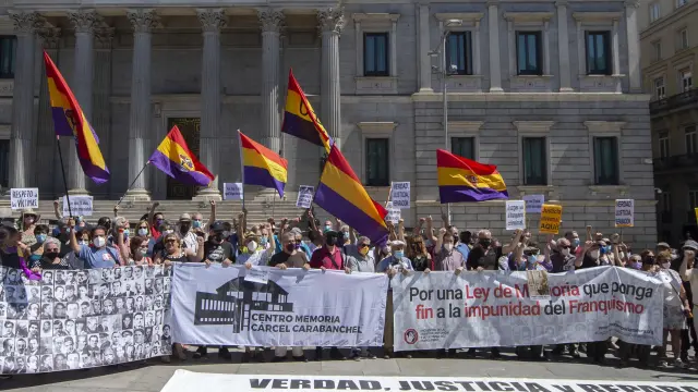 Varias decenas de personas participan en una concentración contra la impunidad del franquismo frente al Congreso de los Diputados, este domingo en Madrid.