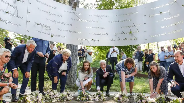 El alcalde de Oslo, Raymond Johansen (i), el príncipe heredero Haakon (4i) y la princesa Mette Marit (2i), entre otras personalidades, en una ofrenda floral en la isla de Utoya, uno de los escenarios de los atentados de hace diez años.