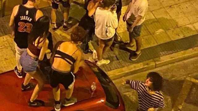 Jóvenes subidos a un coche aparcado en la calle Fita de Zaragoza