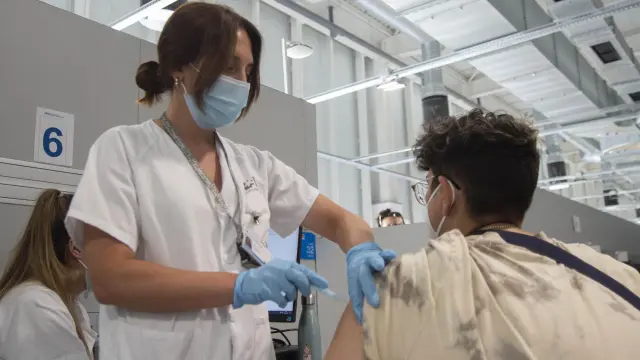 Un joven recibe la primera dosis de la vacuna de Pfizer en el Hospital Zendal.