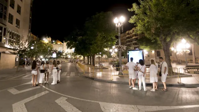 Grupos de jóvenes dispersos por la plaza de Navarra de Huesca poco después de la medianoche.