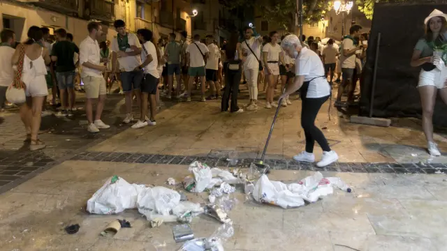Los hosteleros de la plaza de Los Fueros se afanaron en limpiar la basura acumulada durante la primera jornada de las 'no fiestas' de San Lorenzo.