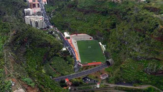 Vista aérea del estadio Silvestre Carrillo de Santa Cruz de La Palma. Es el final de una cuesta de 1 km, junto a la montaña, en un barranco. Al fondo, la capital palmera, con el océano y el puerto.
