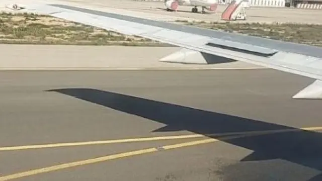 El avión del Real Zaragoza, parado en las pistas del aeropuerto de Ibiza nada más aterrizar, con la pérdida de combustible por el ala izquierda.