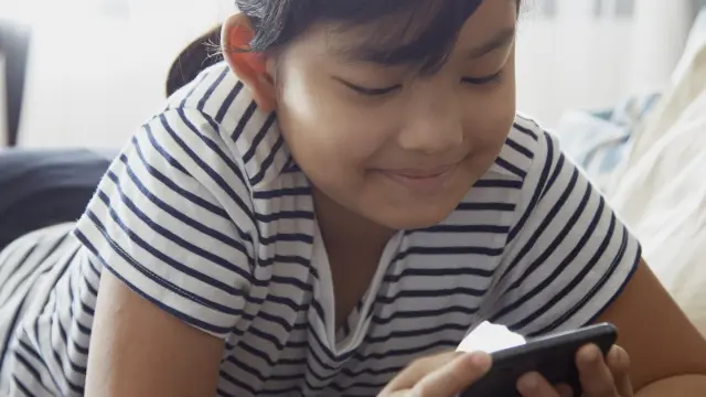 Una niña usando un móvil.