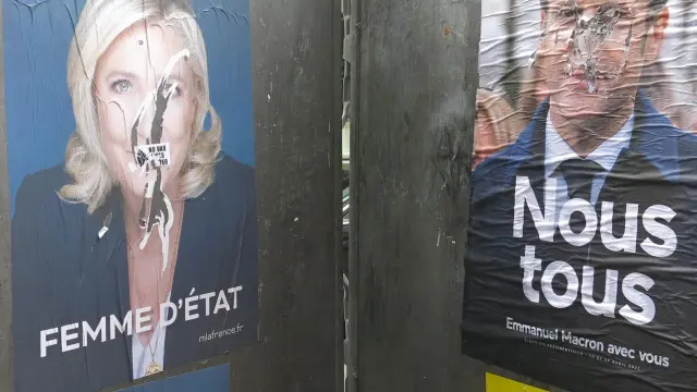 Dos carteles electorales de Emmanuel Macron y Marine Le Pen se "enfrentan" también en las calles de París, este sábado.