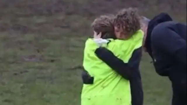 Los dos compañeros de un equipo de rugby se funden en un emotivo abrazo.