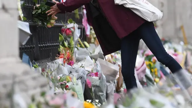 Una persona deja flores a las puertas del Buckingham Palace tras el fallecimiento de Isabel II.