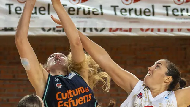 Vega Gimeno trata de taponar el lanzamiento de una jugadora de Valencia Basket, durante el amistoso disputado en Teruel.