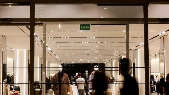 Los compradores pasan frente a una tienda de ropa Zara, parte del grupo español Inditex.