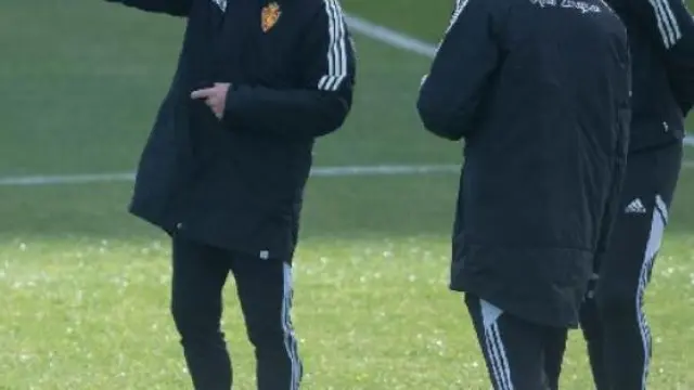 Fran Escribá, acompañado de Generelo y Suárez, indica algo en el entrenamiento del equipo.